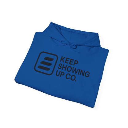 Folded blue hoodie with 'KEEP SHOWING UP CO.' text on a white background
