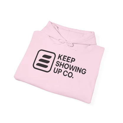 Pink hoodie with 'Keep Showing Up Co.' text on a white background